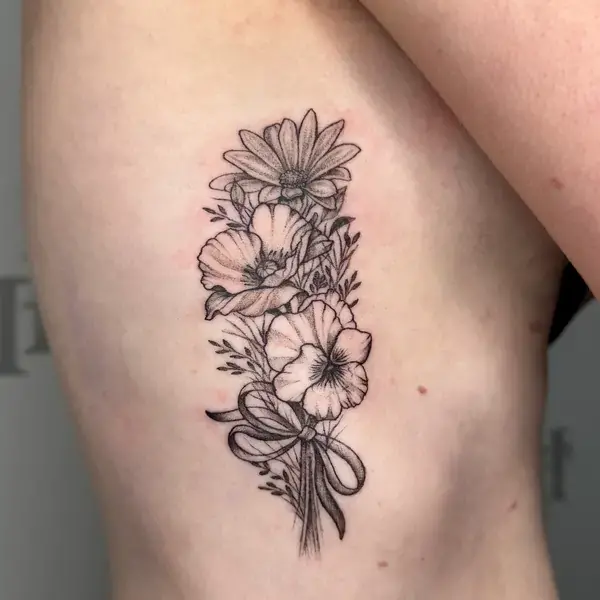 Fine line tattoo of a botanical bouquet with minimalist shading on the ribs by Ruby Gore, fine line tattoo artist portland