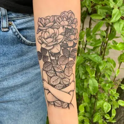 Fine line tattoo of a woman hugging herself and roses with minimalist shading on the forearm by Ruby Gore, fine line tattoo artist portland