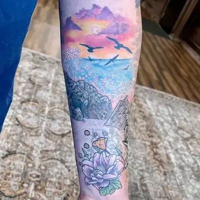 Dreamlike seascape tattoo of Big Sur with waves, peonies, poppies, mountains, and pastel sunset by Ruby Gore, nature tattoo artist portland