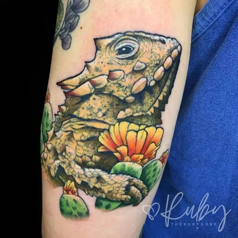 Realistic color lizard tattoo on arm with flowers, naturalistic style