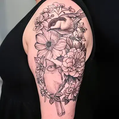 Botanical half-sleeve tattoo with songbirds and layered blooms by Ruby Gore, nature tattoo artist portland